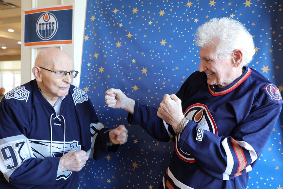 Gilbert Paradis (left) and Ron Espey are enjoying the hockey playoffs and filming TikTok videos at the St. Albert Retirement Residence. On May 17, 2022, they mimic their famous TikTok fight scene. JESSICA NELSON/St. Albert Gazette