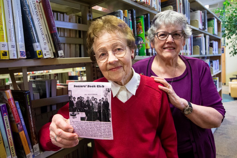 The Seniors Drop-In Book Club at the St. Albert Public Library is celebrating its 20th anniversary and original members Joan Mestinsek, right and Susan Supruniak joined fellow members on Dec. 11 with cake and secret Santa gifts to celebrate two decades of love for books. CHRIS COLBOURNE/St. Albert Gazette