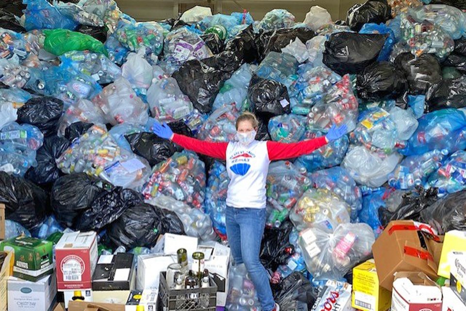 St. Albert RE/MAX Professional Shandrie Lewis in front of the mountain of donations collected  through their bottle drive on April 24. In one day, their team managed to raise more than $18,000 for the St. Albert Food Bank. SUBMITTED