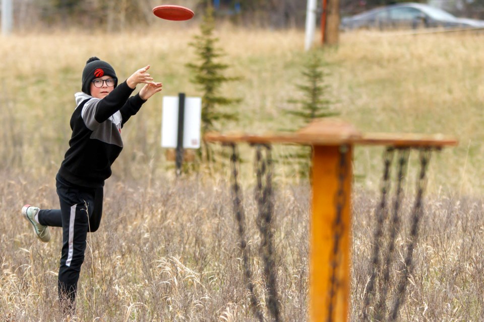 THROW LONG AND PROSPER: Beckett Ashworth, 12, putts towards the basket at the Town of Cochrane Dic Golf Course on Monday (May 11). (Chelsea Kemp/The Cochrane Eagle)