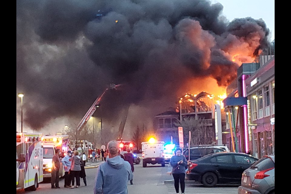 Fire trucks battle back flames at the top of the building. APRIL HUDSON/Photo