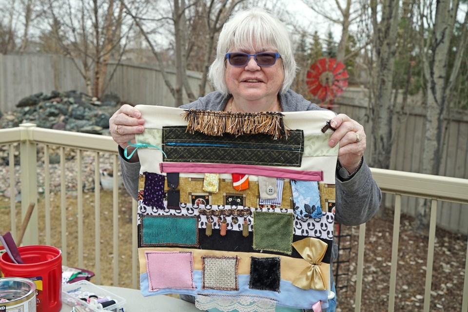 Willa Bosch holding up one of her special lap quilts at her home in St. Albert. Willa donates these quilts to patients at the Sturgeon Community Hospital. BRITTANY GERVAIS/St. Albert Gervais