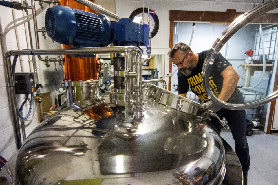 Johannes Irnich checks the still at the family's DaVinci Gelato business in Riel Park on Tuesday. The local business has continued to adapt by creating new products like rum and vodka and by making hand sanitizer which is much in demand these days thanks to COVID-19. CHRIS COLBOURNE/St. Albert Gazette