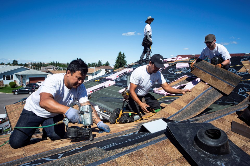 Crew members from Roe Roofing & Exteriors in St. Albert once again volunteered to replace a roof for a deserving family, this time in Edmonton, on Friday. CHRIS COLBOURNE/St. Albert Gazette