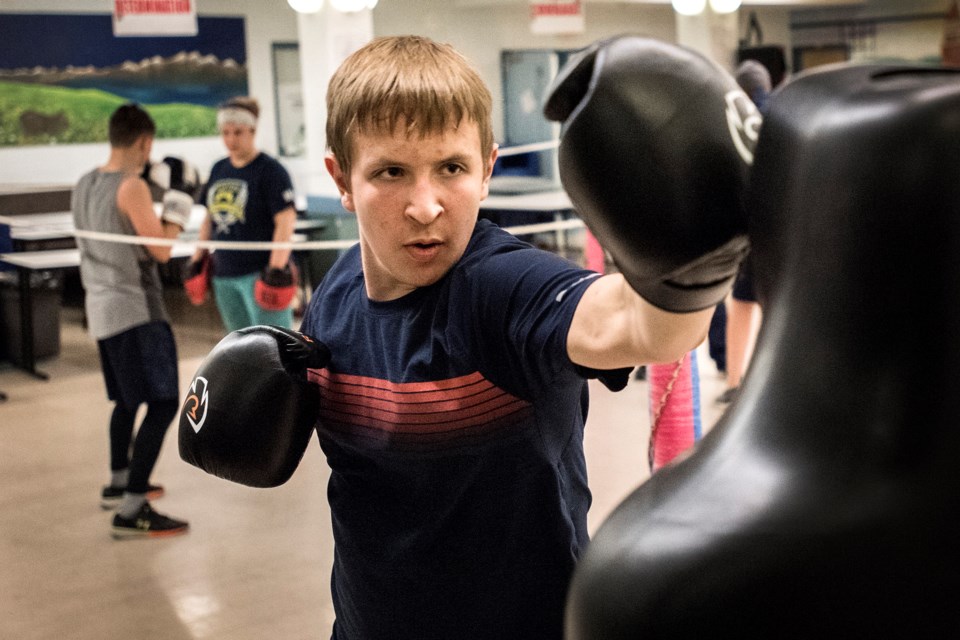 PUNCHER – Reid Pidsadowski of the St. Albert Boxing Academy works on the dummy bag at Wednesday's training session at Sir George Simpson School. In the background are Jacob Wiwchar and Susan Haas. The St. Albert academy is hosting a Boxers Against Bullying club card next Saturday at 2 p.m. at St. Albert Community Hall.
DAN RIEDLHUBER/St. Albert Gazette