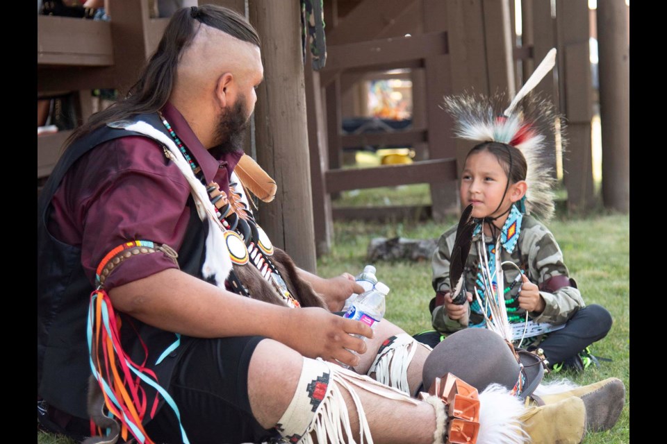 Broken Heavyshield (left) and Decker Wells, 7, take a water break from the heat at the Alexander First Nation traditional powwow on Aug. 20, 2022. 
BRUCE EDWARDS/St. Albert Gazette