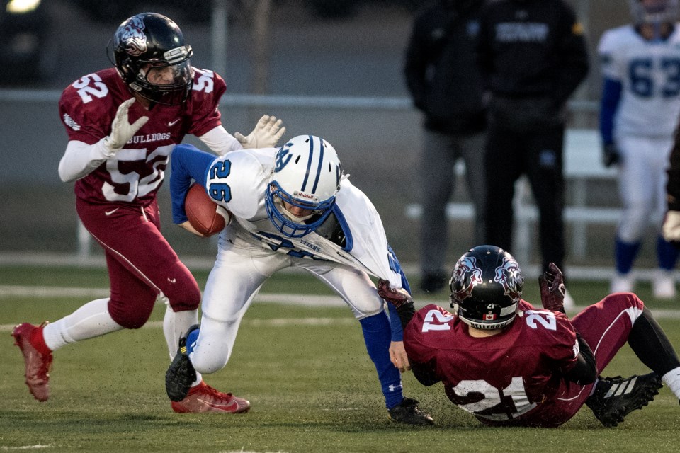 GROUNDED – Dominic Escamilla, left, and Brennan Loblick of the Bellerose Bulldogs take down the Harry Ainlay Titans' ball carrier in Wednesday's division one pool B semifinal in the metro Edmonton junior league. Bellerose won 24-13 at Larry Olexiuk Field. Tuesday's final between Bellerose (4-1) and the pool A Salisbury Sabres (5-0) kicks off at 7:30 p.m. at Clarke Stadium. In the pool A versus pool B regular season, Bellerose lost 48-16 to Salisbury.
DAN RIEDLHUBER/St. Albert Gazette