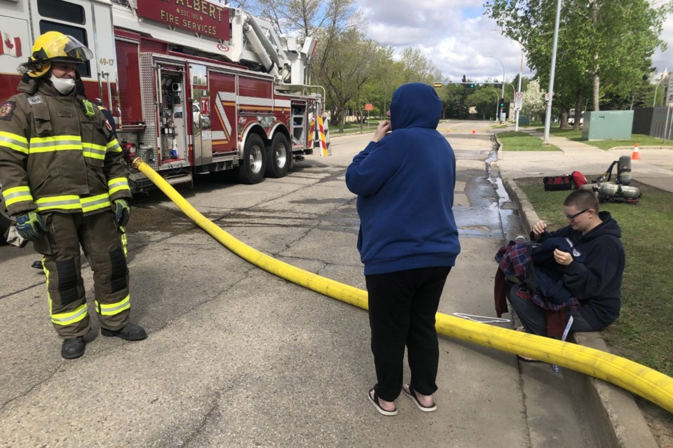 Denise and Chelsea (right) thank a St. Albert firefighter for bringing some clothing from their apartment suite. The two left with nothing but the clothes on their back and the family cat after realizing there was a fire. BRITTANY GERVAIS/St. Albert Gazette 