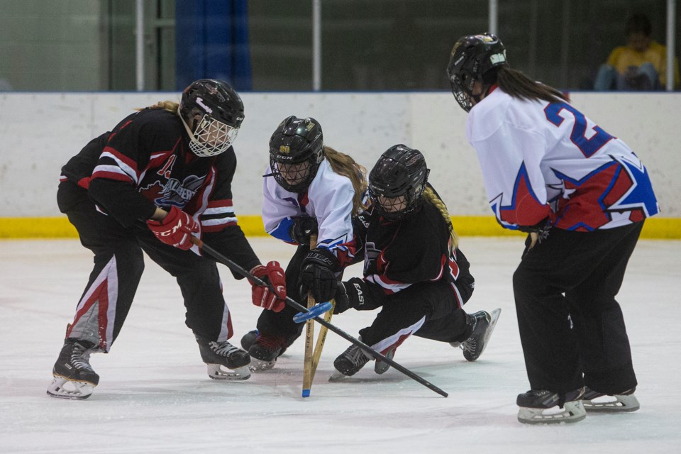 STICKING IT – Kenzie McEachern, left, sticks the ring with support from Brooke Maurier of the U16AA St. Albert Mission in Saturday's pool B game against the Manitoba Magic at the 34th annual Wood Invitational Tournament at Terwillegar Community Recreation Centre. The Mission won 5-2 as Kirsten Krochak potted a pair. The Mission finished 3-2 in the 10-team draw after losing Sunday's playoff for bronze 3-2 to Sherwood Park Power. 