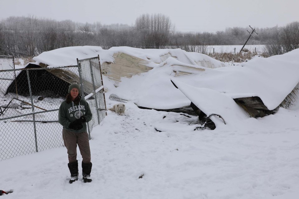 Terra Maclean stands in front of the charred remains of her barn near Busby, Alta., on Dec. 23, 2021. Altogether, 17 rescue animals were lost in the Dec. 20, 2021 fire. JESSICA NELSON/St. Albert Gazette