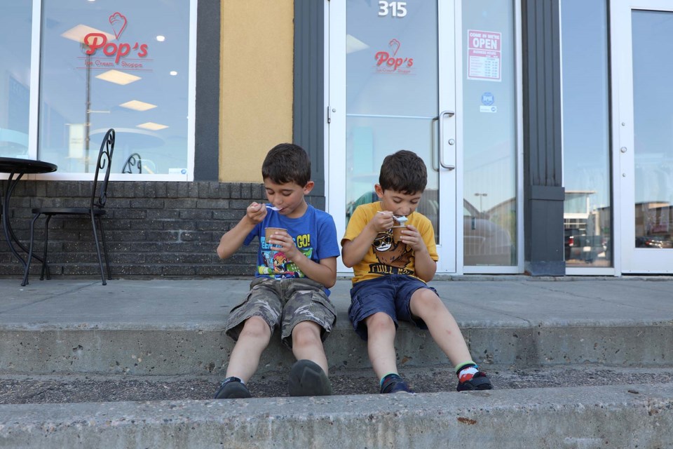 Noah (left) and Daniel Gibran cooled off with an ice cream outside Pop's Ice Cream Shoppe as temperatures rose on Saturday, June 26, 2021. JESSICA NELSON/St. Albert Gazette.
