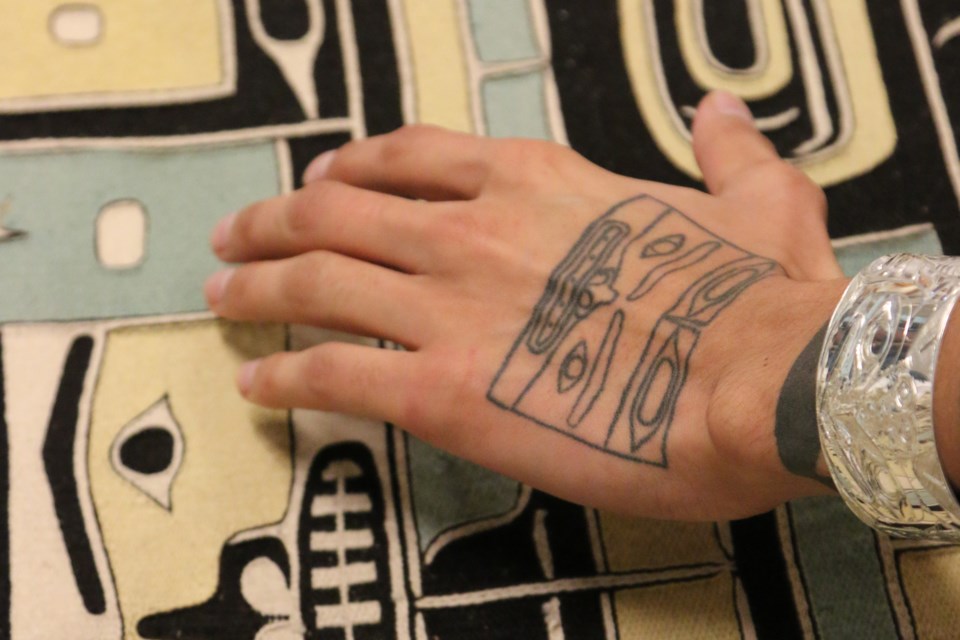 Portrait of a Chilkat robe and hand tattoo. 