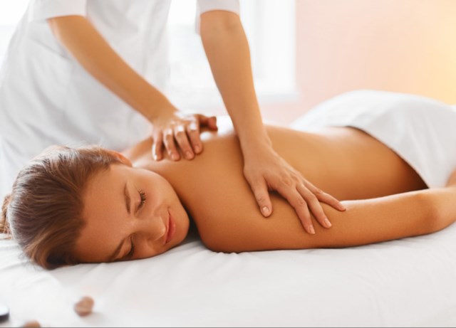 Spa treatment. Woman enjoying relaxing back massage in cosmetology spa centre. Body care, skin care, wellness, wellbeing, beauty treatment concept.