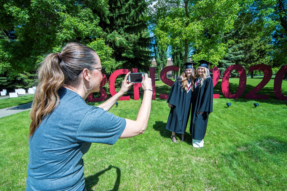 Kiersten Girard, right and Caitlyn Girard pose for a photo shot by Bellerose teacher Meredith Kazuro during the school grad day for Gr. 12 students. The day-long event included the full cap and gown treatment with a photo shoot, wood fired pizza and a gift bag. CHRIS COLBOURNE/St. Albert Gazette
