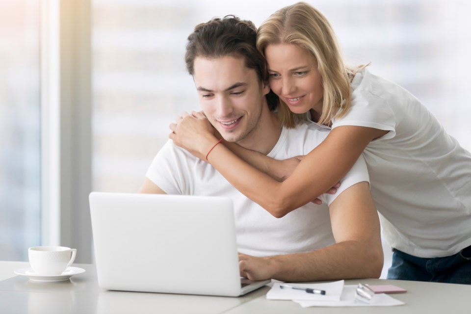 4-young-happy-couple-with-laptop-PBUA6YS