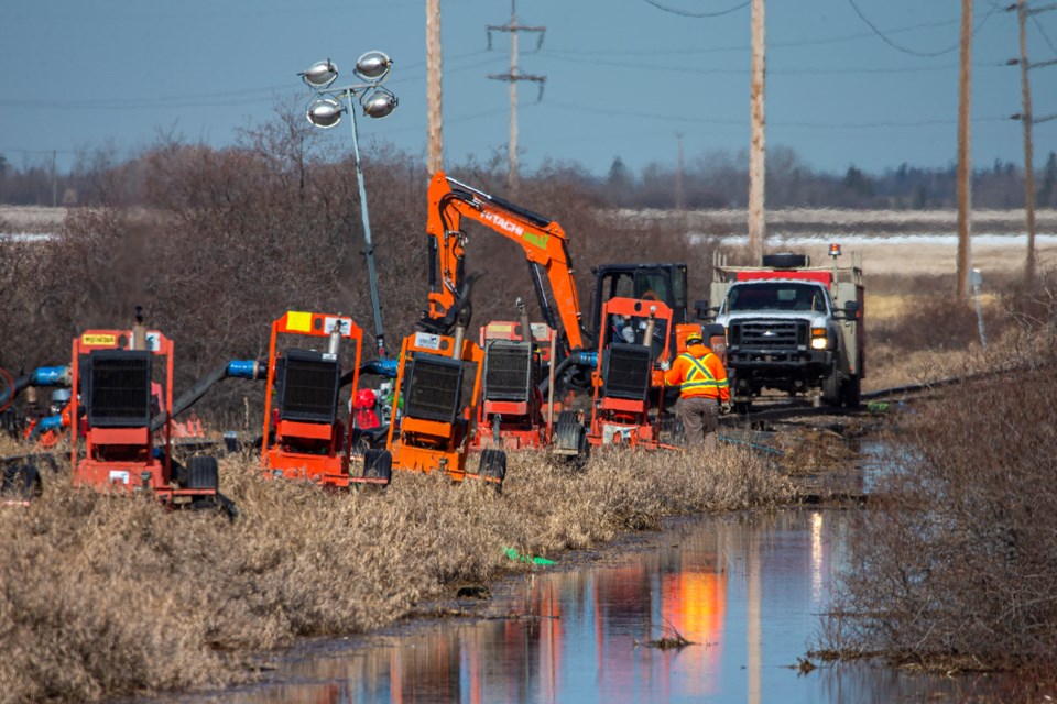 CN crews were busy Monday morning just west of Ray Gibbon Dr. as they assembled a series of pumps to remove standing water from a field adjacent to a rail corridor. CHRIS COLBOURNE/St. Albert Gazette