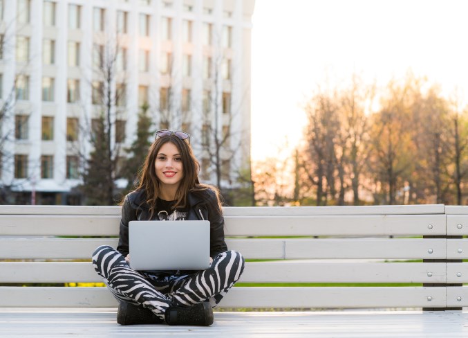 student-sitting-on-bench-on-campus