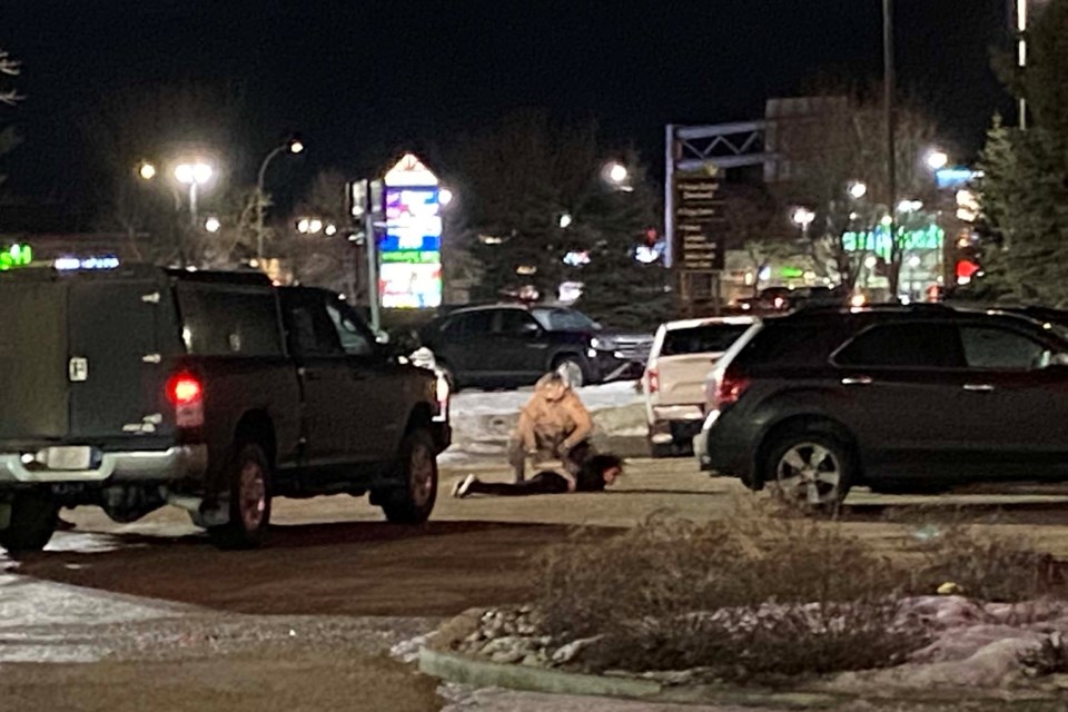 An officer in tactical clothing apprehends a female after she exits the Canadian Brewhouse on the south end of St. Albert on Thursday evening, Feb. 10, 2022. SUPPLIED/Photo