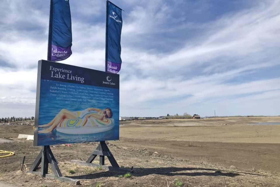 A sign advertising lake living at the entrance of Jensen Lakes stands in stark contrast to how the future site of the lake development looks now. BRITTANY GERVAIS/St. Albert Gazette