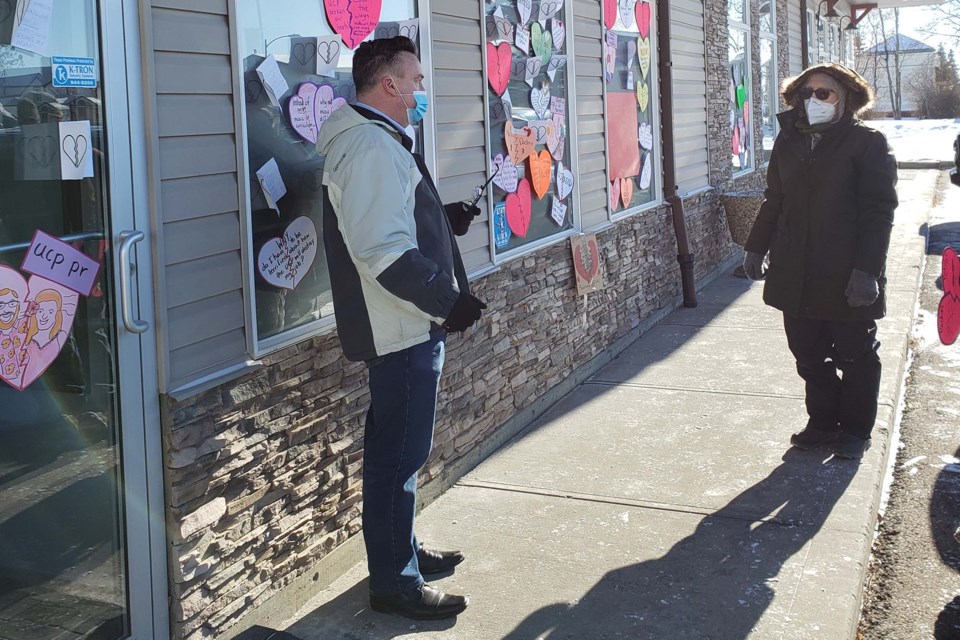 The front of Morinville-St. Albert MLA Dale Nally's constituency office was decorated last weekend by protesters who made heart-shaped signs highlighting issues they had with the UCP government. Nally, left, engages with a protester outside his office. JAN CHAPMAN/Photo