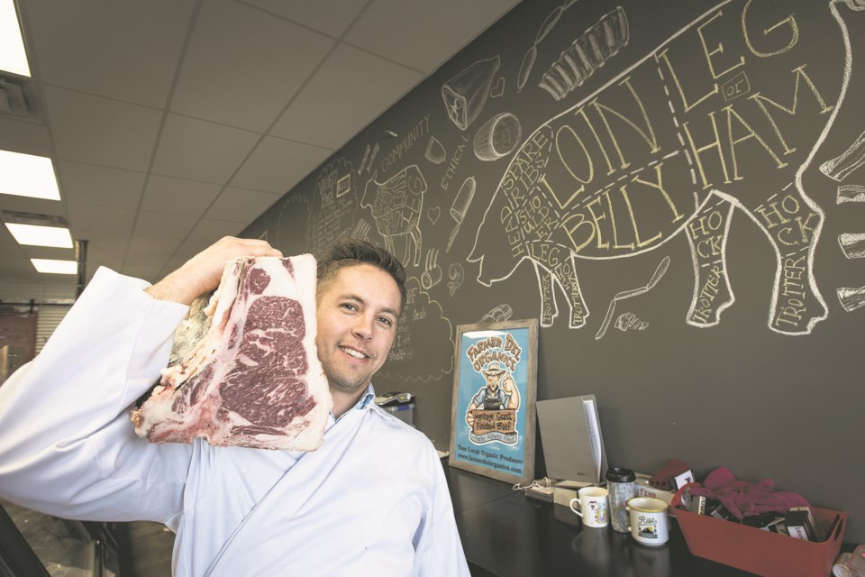 Kyle Iseke, owner of Darcy's Meat Market, shoulders a large piece of Wagyu beef behind the counter of his Campbell Park store in St. Albert in April  2018. FILE PHOTO/St. Albert Gazette