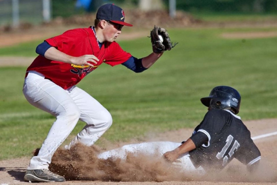 Former Bantam AAA Cardinals player Aaron Larose attempts to tag an opposing player in 2011 game at Legion Memorial Park. FILE PHOTO/St. Albert Gazette