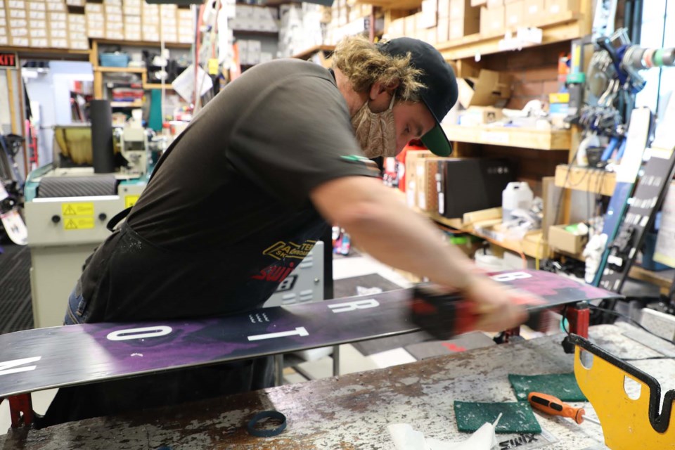Mathew Johnston buffs a snowboard at Pacesetter Ski and Snowboard on Nov. 29, 2021. JESSICA NELSON/St. Albert Gazette