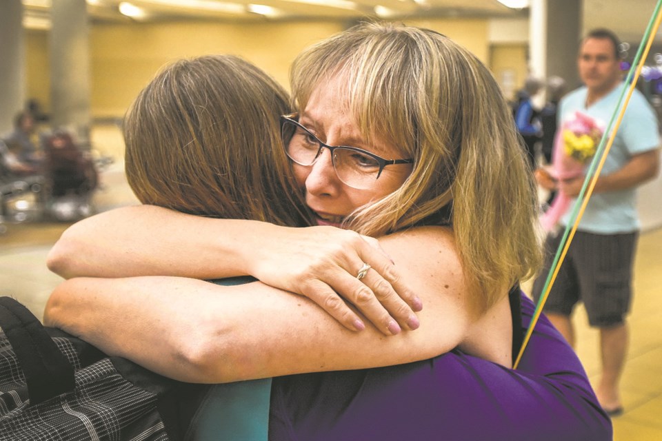 Velvet Martin of St. Albert, right, hugs her sister for the first time at the Edmonton International Airport on Tuesday.  Bonnie Williamson-Powell arrived from Ontario for a week-long visit with her newfound sister. DAN RIEDLHUBER/St. Albert Gazette