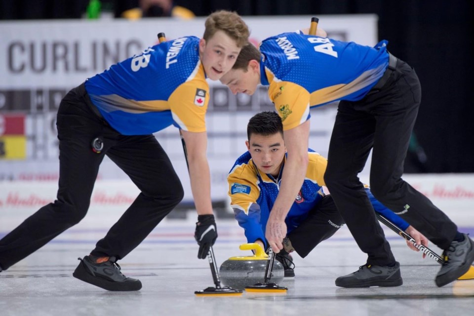 Johnson Tao (middle) throws a rock while Andrew Nowell (left) and Ben Morin sweep at the New Holland Canadian Junior Curling Championships held in Stratford, Ont. from March 26 to April 1, 2022. SUPPLIED/Photo