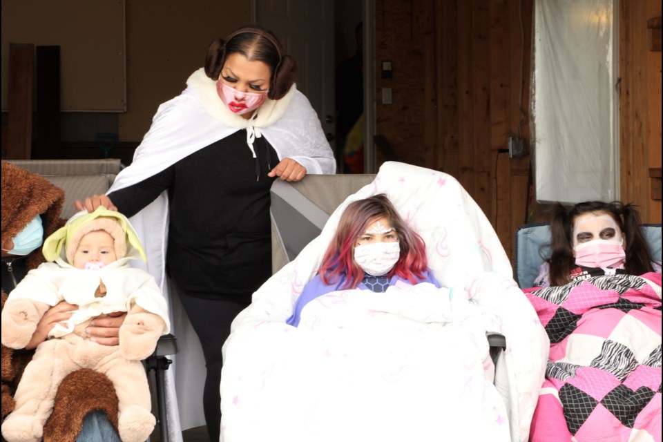 Arizona Burns watches the Halloween parade outside her house from a distance. JESSICA NELSON/St. Albert Gazette