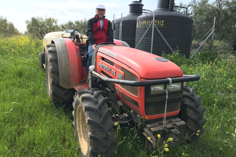 St. Albert olive oil hobby farmer George Pananos is the owner of an olive producing farm in Greece. Taken in 2019, this photo shows the St. Albert resident pulling a sprayer filled with a copper fungicide, a traditional organic practice to deter pests and disease. 
