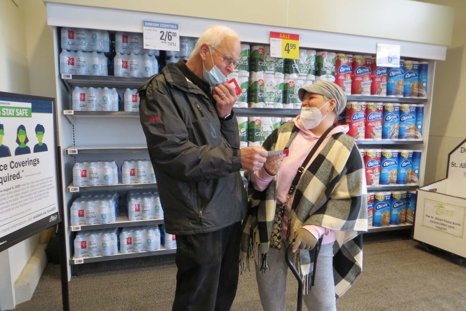 Local resident Kim Basma shares a joke with Kinsmen Glen Steiner upon receiving a free $25 gift card as part of Kin Canada's National Day of Kindness. ANNA BOROWIECKI/St. Albert Gazette