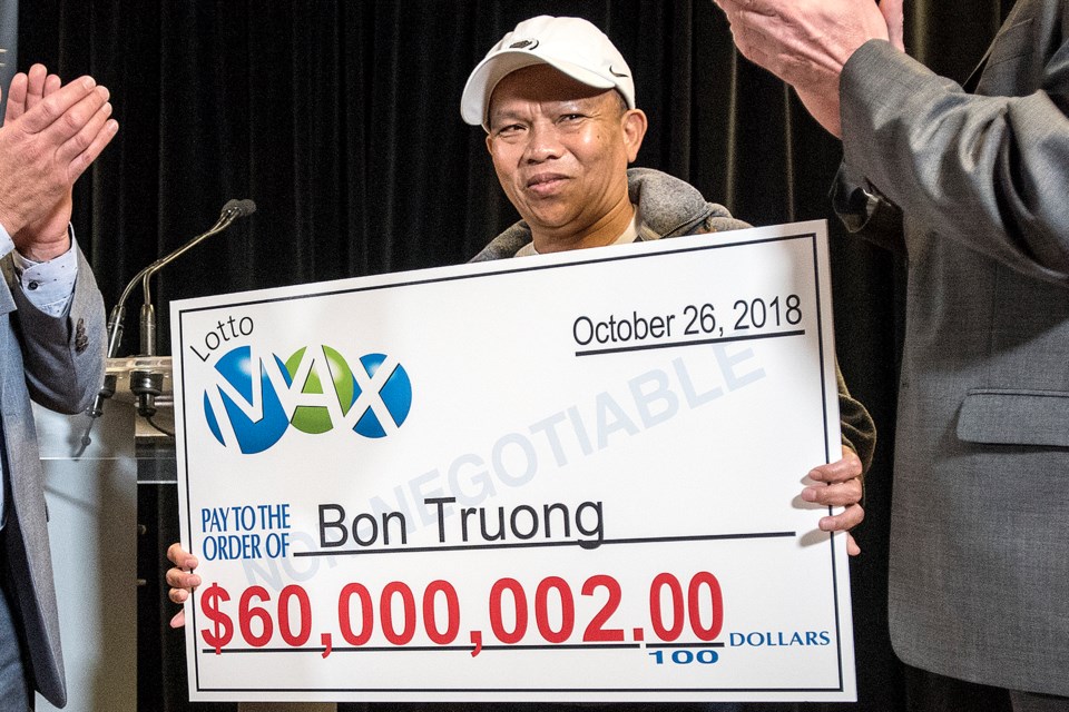 Lotto Max winner Bon Truong receives his cheque from Alain Maisonneuve, left, president and CEO of AGLC, and Len Rhodes, AGLC board chair, at AGLC headquarters in St. Albert on Wednesday, Aug. 28, 2019. DAN RIEDLHUBER/St. Albert Gazette