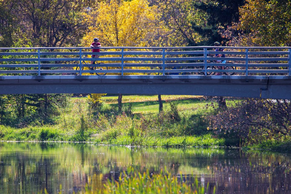 A cyclist stops to admire the view of the fall colours reflected in the Sturgeon River near Rivercrest Crescent on Sunday, Sept. 22. CHRIS COLBOURNE/St. Albert Gazette