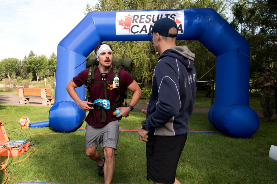 A race official reaches out to congratulate Cpl. Nicolas Cazelais as he becomes the first to cross the finish line at the 2019 Mountain Man challenge at Edmonton's Rundle Park on Aug. 29. Cazelais set a new course record with his time of 4:58:19. 
KEVIN MA/St. Albert Gazette
