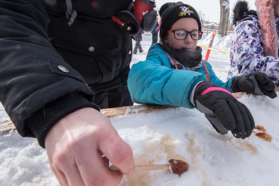 An example of a Cabane a sucre treat — rolling snow-covered syrup onto a stick.    JOHN LUCAS/St. Albert Gazette