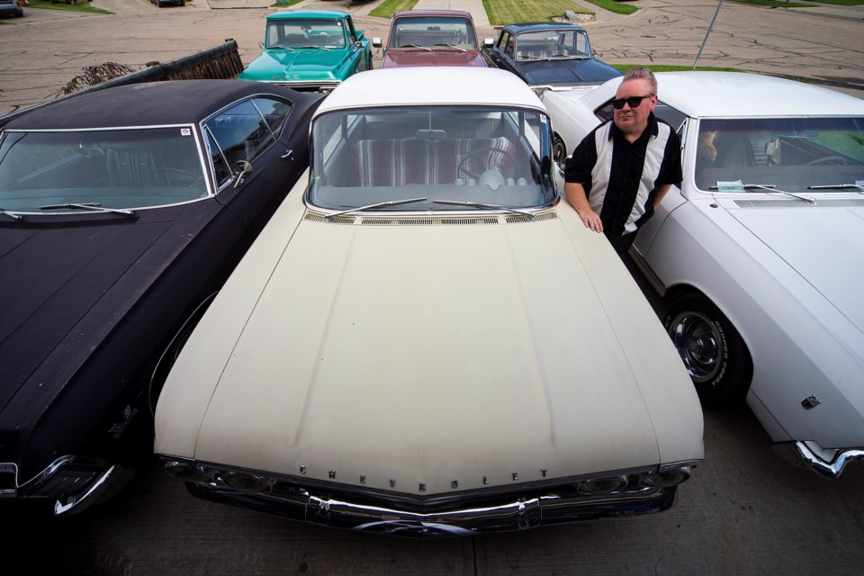 Greg Charters of St. Albert poses with his classic cars – all GMC or Chevrolet models – at his home. CHRIS COLBOURNE/St. Albert Gazette