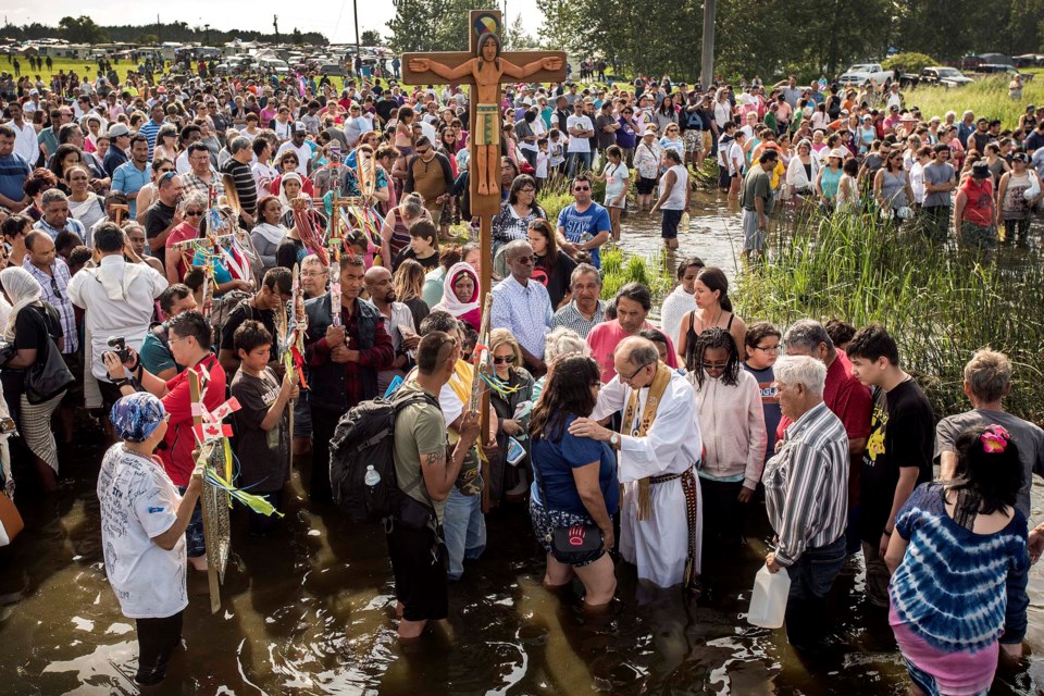Archbishop Emeritus Sylvain Lavoie of St. Albert's Star of the North blesses attendees during the Blessing of the Lake ceremony at Lac Ste. Anne on July 21, 2019. DAN RIEDLHUBER/St. Albert Gazette