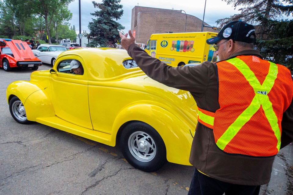 Gary Warren, right, a St. Albert Cruisers member helps direct Dave Jolivette's 1936 coupe into place as classic cars filled up the downtown for the annual car show and street dance on Friday night as part of Rock'n August celebrations. CHRIS COLBOURNE/St. Albert Gazette