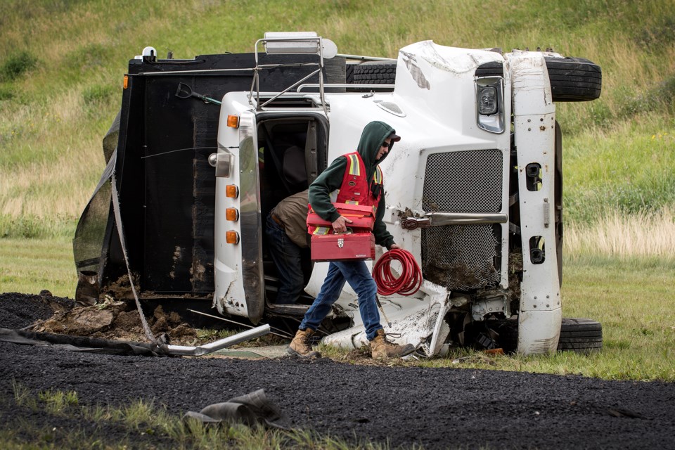 A man removes items from an asphalt truck at the scene of a rollover collision involving this truck and a pick up truck on Ray Gibbon Dr. just north of LeClair Way around 11 a.m. DAN RIEDLHUBER/St. Albert Gazette