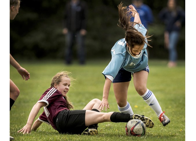 STUMBLED – Emma Richardson of the Paul Kane Blues is tripped up by Sykora Thornton's sliding tackle for the Bellerose Bulldogs in Friday's metro Edmonton division two women’s semifinal at Forest Park field. Paul Kane won 4-0 and the score in Tuesday's final against the St. Francis Xavier Rams was unavailable at press time. Paul Kane (6-1) and the Rams (7-0) are pool B teams and Bellerose (4-1-2) competed in pool A.
DAN RIEDLHUBER/St. Albert Gazette