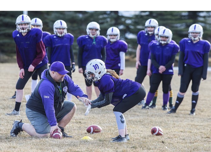 HELPING HAND – Assistant coach Geoff Richer demonstrates how to position the hands to receive a snap from centre to Charley Tourond of the St. Albert Valkyries at Wednesday’s practice at Oakmont park. The Valkyries are one of four Capital District Minor Football Association teams competing in the inaugural six-on-six midget female spring league.
CHRIS COLBOURNE/St. Albert Gazette