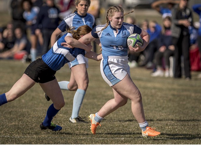 LEADING THE WAY – Calleigh-Ann Woodworth of the Paul Kane Blues slips a tackle from Angeline Sturko of the Harry Ainlay Titans in Tuesday's metro Edmonton division two women's match at St. Albert Rugby Football Club. In the background is Ainsley Maxwell of Paul Kane. Woodworth, an inside-centre, scored two tries and set up a third in the 29-5 victory. Paul Kane lost last year's final to Ainlay 27-12. The next match for Paul Kane is Tuesday against the Archbishop Jordan Scots and both teams are 2-0. Kickoff is 4:45 p.m. at Lynn Davies Rugby Park.
DAN RIEDLHUBER/St. Albert Gazette