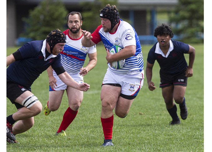 UNTOUCHABLE – Angus (Gus) MacDonald powers past a Clansman with Matt Jarvis following in support of his St. Albert Rugby Football Club teammate in the Alberta Cup premier men's match Saturday. MacDonald set up Jarvis for the first of his two tries as the defending Labatt's Cup provincial champions scored nine tries in the 62-13 dismantlement of the Clan at SARFC. 
CHRIS COLBOURNE/St. Albert Gazette