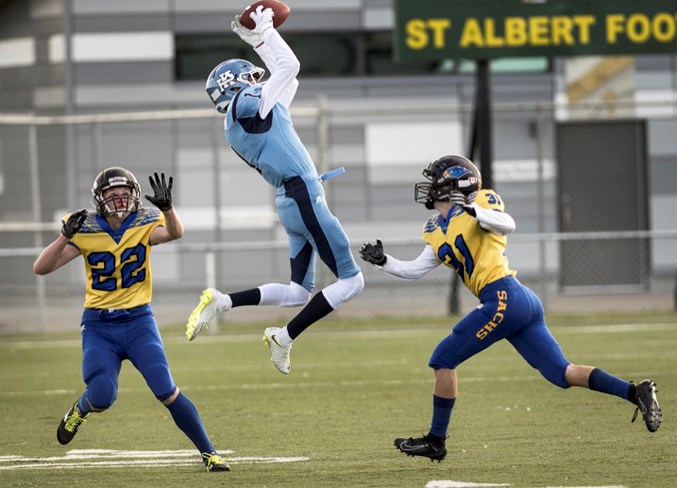 LEAPING CATCH – Ty Bates of the Paul Kane Blues goes sky-high to grab the football against Addison Ross, left, and Derek Dubrule of the St. Albert High Skyhawks in Friday's rivalry game at Larry Olexiuk Field. Paul Kane won 17-14. 
DAN RIEDLHUBER/St. Albert Gazette