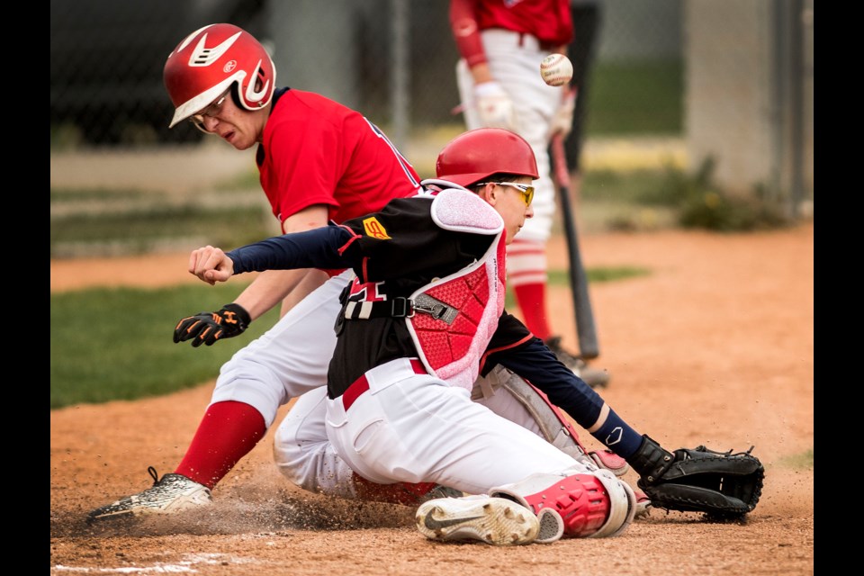 The ball gets away from St. Albert Cardinals' Blue catcher Lyall McMillan as Fort Saskatchewan Red Sox baserunner Colby Meyers scores during U18 midget AA baseball action at Memorial Park in St. Albert. DAN RIEDLHUBER/St. Albert Gazette