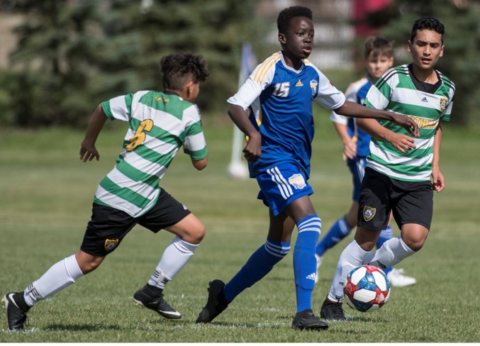ATTACKING – Anyole Peter of St. Albert Impact (Jones) splits the defence against Foothills FC 13 in Saturday's group two match at the U13 Tier I provincials at Riel Park. Joseph Ndakala's goal with 11 minutes remaining broke a 1-1 tie as the Impact won 2-1 to finish 3-0 in pool play at the eight-team tournament. Sunday's final was 1-0 for Springbank SC as the Impact suffered their first loss of the season.
JOHN LUCAS/St. Albert Gazette