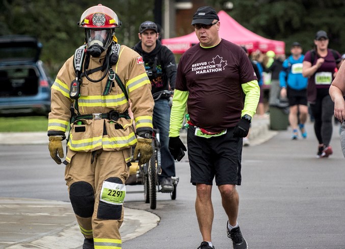 Olds firefighter Noel D'Arcy walks at about the halfway point of the Edmonton half-marathon in full firefighter's gear attempting a Guinness World Record. DAN RIEDLHUBER/St. Albert Gazette
