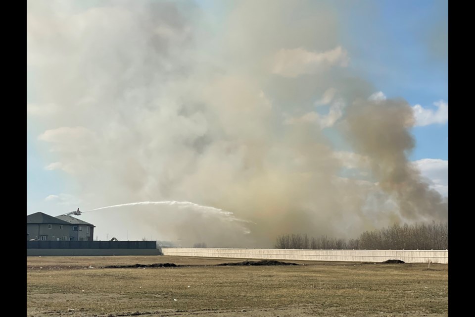 Edmonton firefighters battle a bush fire on Monday afternoon. The fire has closed the eastbound lane of the Anthony Henday near 127th street. 