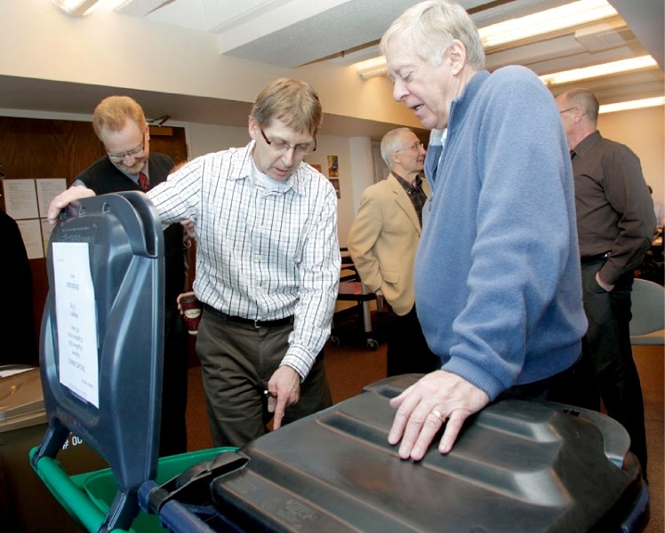 Public works Director Glenn Tompolski shows councillors Malcolm Parker (right) and Wes Brodhead a prototype of the new toters the public will be getting for the new garbage